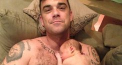 Robbie Williams holding his baby girl Teddy